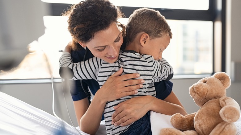 Mom comforting sick child at the hospital