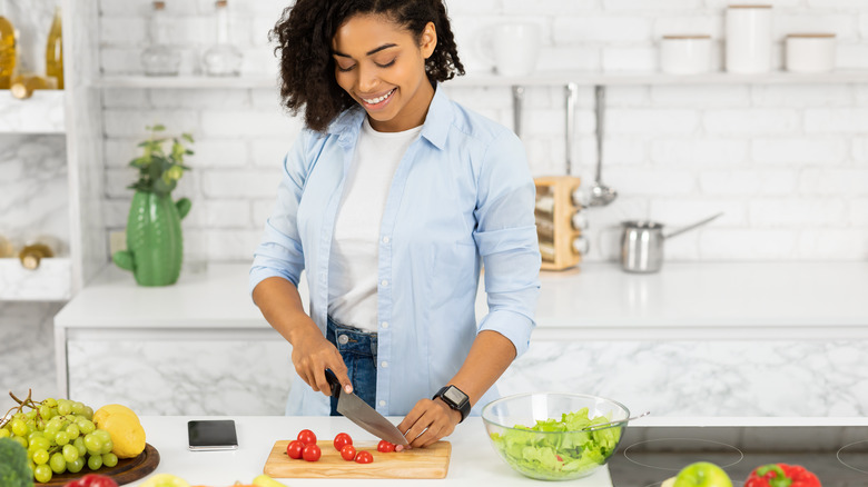 Healthy young woman preparing a salad 