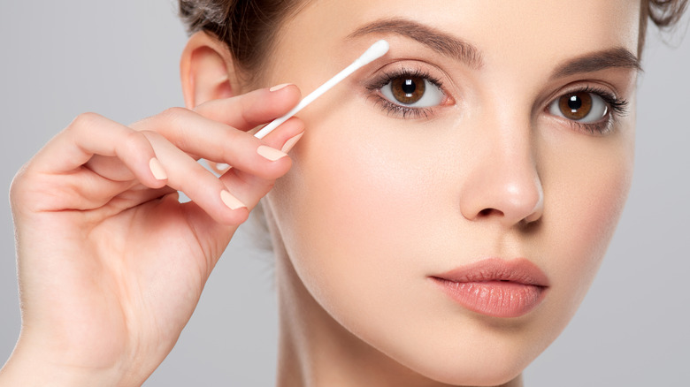 Woman using cotton swab 