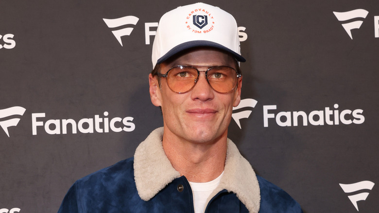 Tom Brady wearing a cap and tinted glasses