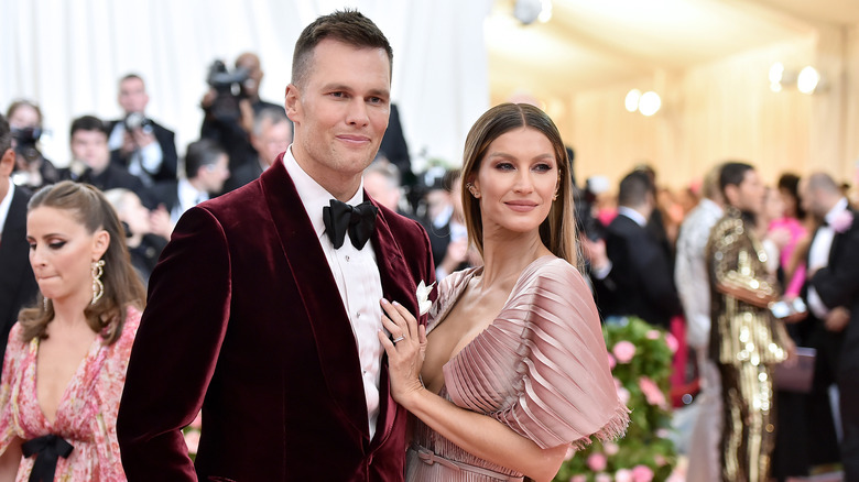 Tom Brady and Gisele Bündchen at the MET Gala in a red velour suite and blush pink gown.