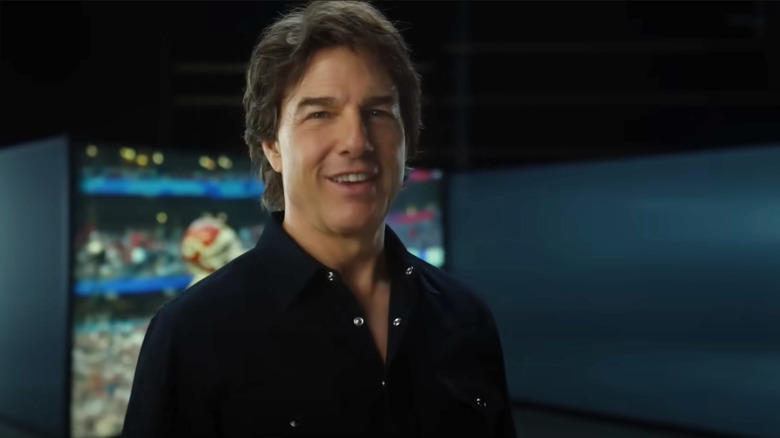 Tom Cruise in minimalist room standing in front of screen
