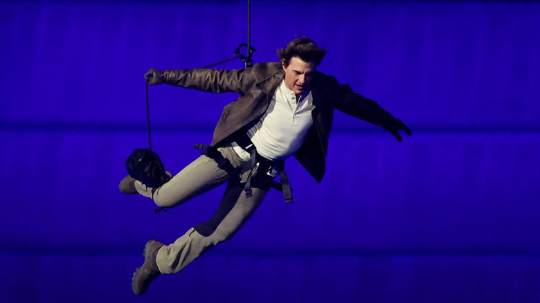 Tom Cruise in mid-air as he rappels