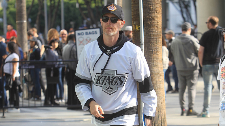 Colin Hanks wearing a Los Angeles Kings sports jersey and cap.