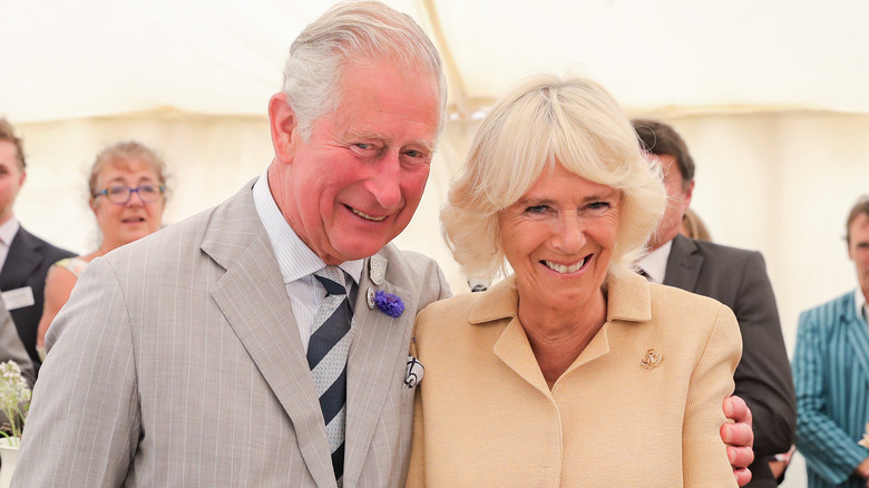 King Charles and Queen Camilla grinning