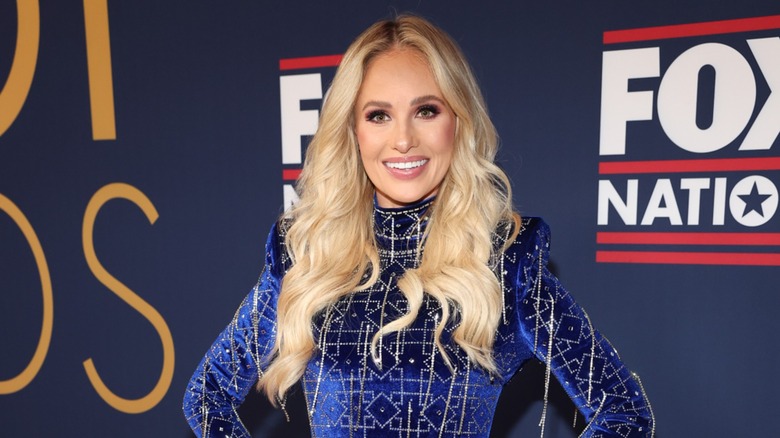 Tomi Lahren with her hands on her hips in a blue dress.