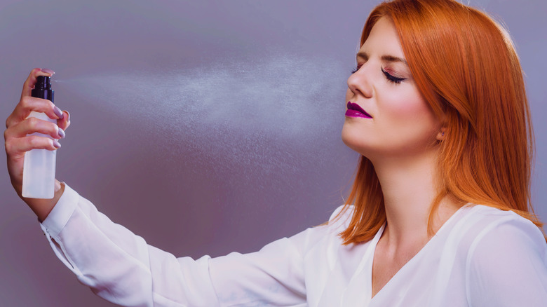 Woman setting her makeup with spray