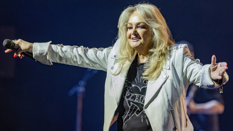 Bonnie Tyler holding out her arms to the audience.