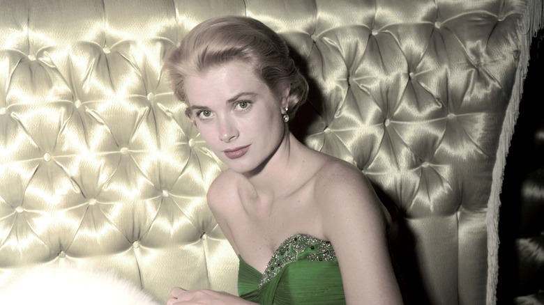 Grace Kelly in a strapless green gown sitting on a golden couch