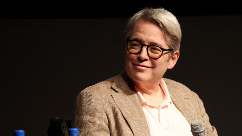 Matthew Broderick smiling with gray hair in a beige blazer