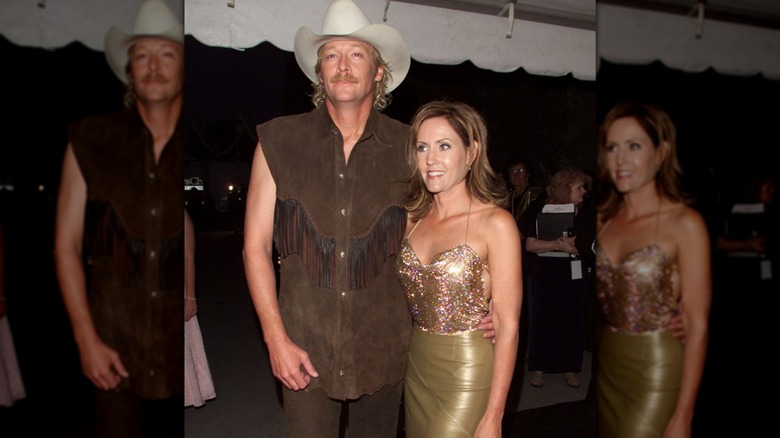 ,Alan Jackson in brown fringe sleeveless shirt and cowboy hat with wife Denise in bronze skirt and sparkly, strappy top