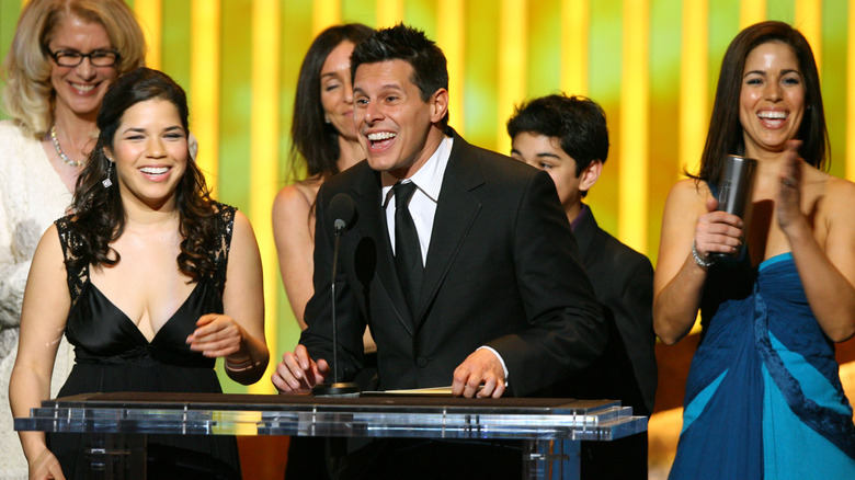 America Ferrera on stage smiling with the "Ugly Betty" cast