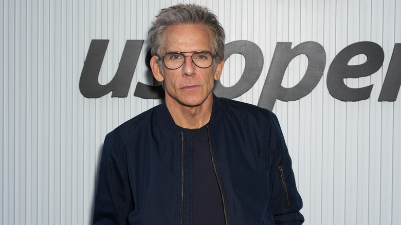 Ben Stiller posing for photos in a blue jacket and glasses