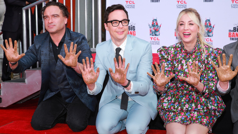 Jim Parsons cementing his handprints alongside Kaley Cuoco and Johnny Galecki