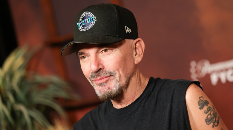 Billy Bob Thornton posing for photos in a black cap and matching sleeveless shirt