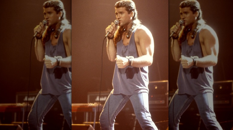Billy Ray Cyrus performing in jeans and a gray muscle shirt
