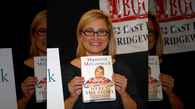 Maureen McCormick holds up her memoir