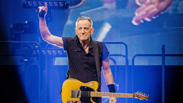 Bruce Springsteen performing onstage while pointing
