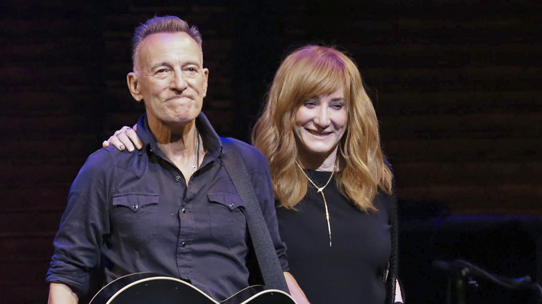 Bruce Springsteen and  Patti Scialfa smiling together on stage