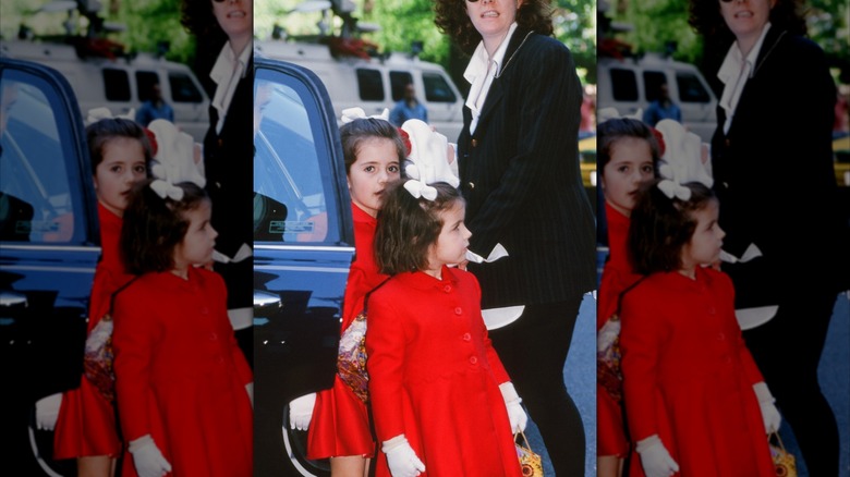 Edwin Schlossberg, husband of Jacqueline Kennedy Onassis's daughter Caroline, leads his daughters Rose (L) and Tatiana (R) from their grandmother's apartment building