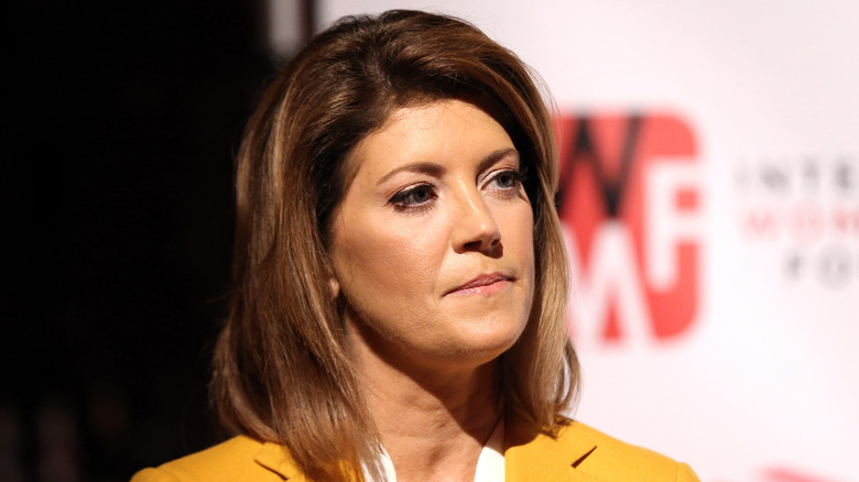 Close up of Norah O'Donnell, cast partially in shadow in a yellow suit.