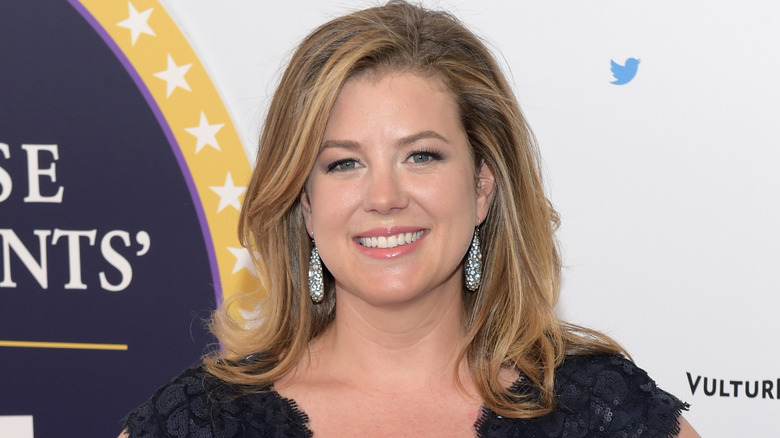Brianna Keilar smiling in front of white backdrop