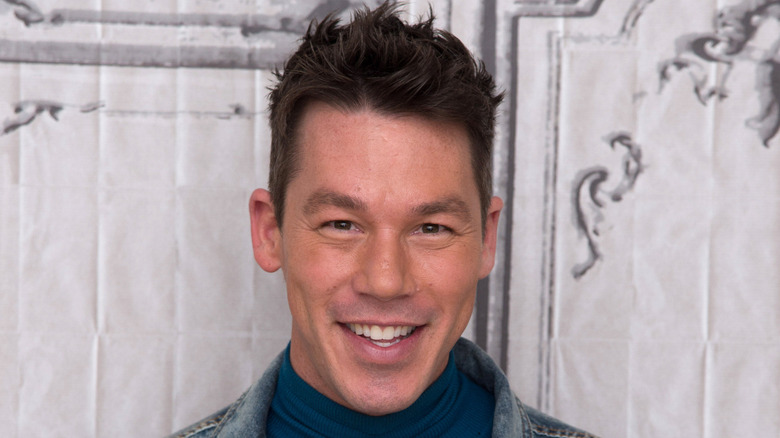 David Bromstad denim jacket in front of ornamental background