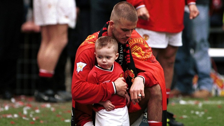 David Beckham with a young Brooklyn Beckham on soccer pitch