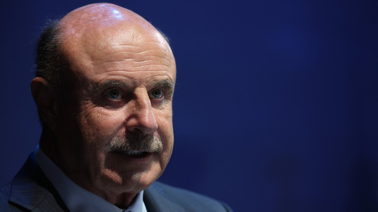 somewhat ominous photo of Phil McGraw, with part of his face covered by shadows