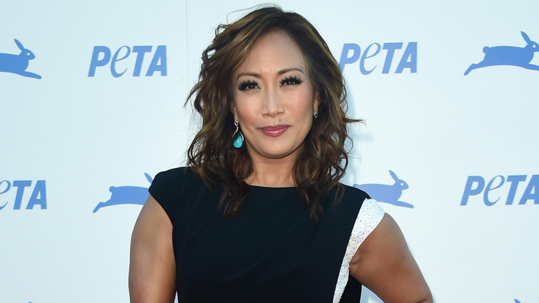 Carrie Ann Inaba wearing a black dress with a white stripe