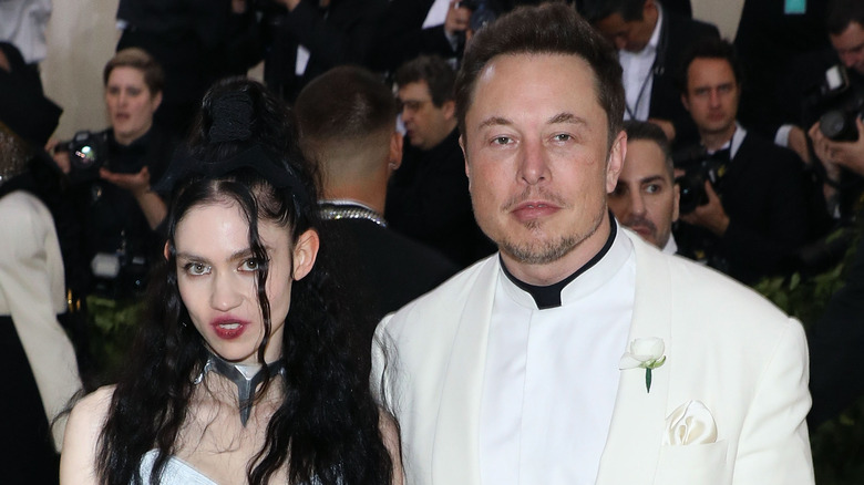 Elon Musk and Grimes posing for photos