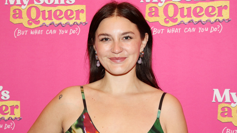 Gracie McGraw smiling in front of pink backdrop