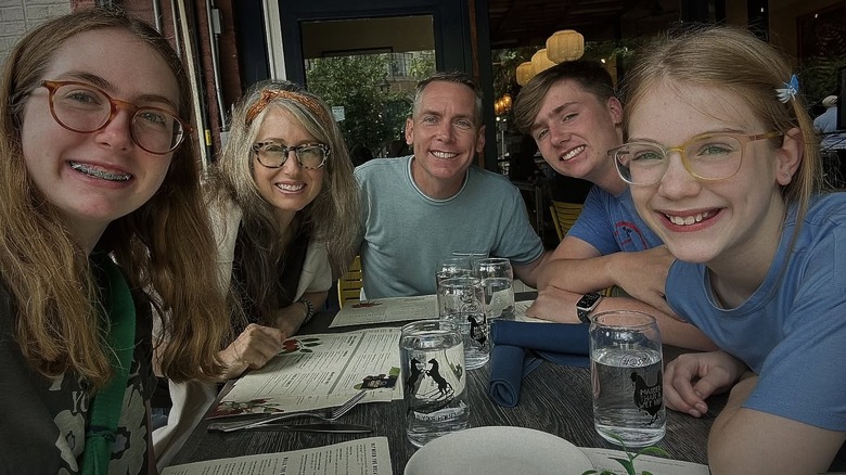Clint Harp poses with his wife and three kids in a restaurant