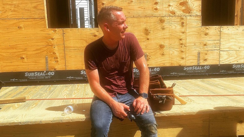 Clint Harp poses on the site of a home he's building.
