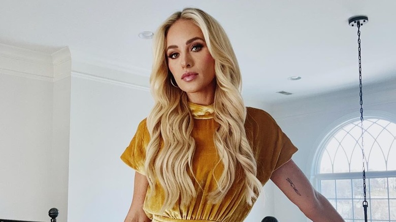 Tomi Lahren posing on a staircase with a neutral expression