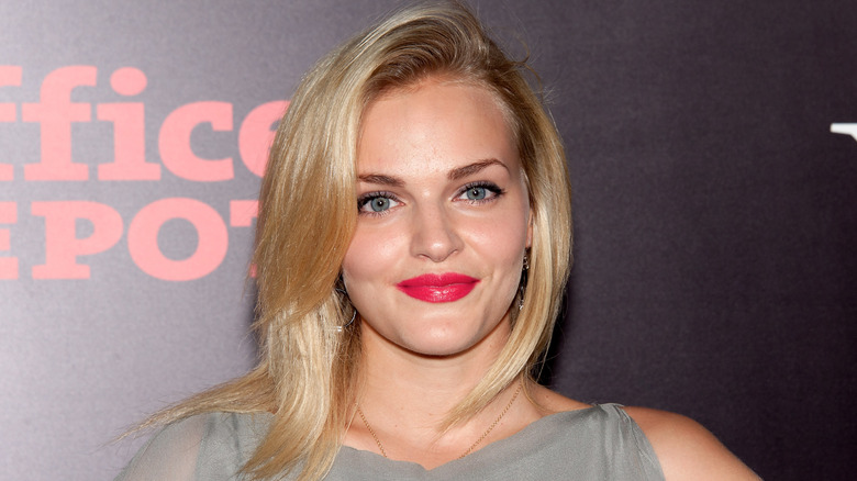 close up of Madeline Brewer with blonde hair and red lips in a gray dress