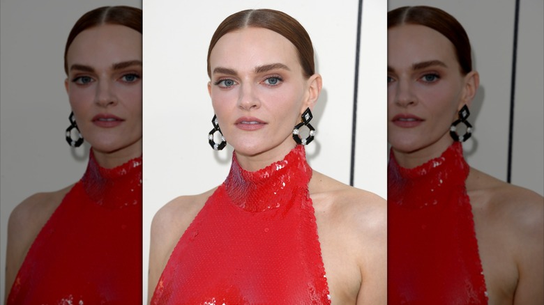 Madeline Brewer in red sequin halter dress and black earrings with hair slicked back
