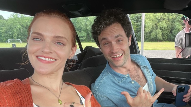 Madeline Brewer and Penn Badgley smiling in a car selfie
