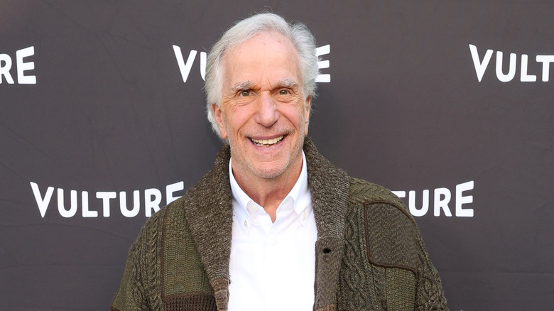 Henry Winkler smiles on a red carpet.