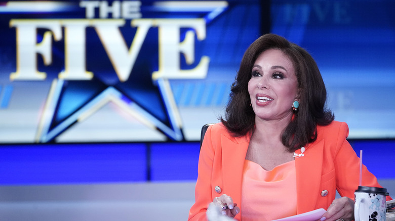 Jeanine Pirro smiling in an orang outfit on the set of "The Five"