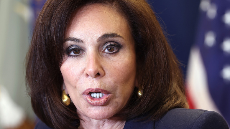 Jeanine Pirro open-mouthed mid-speech in gold earrings and a black blazer