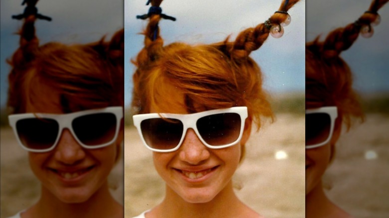Young Jessica Chastain smiling and wearing braids and sunglasses