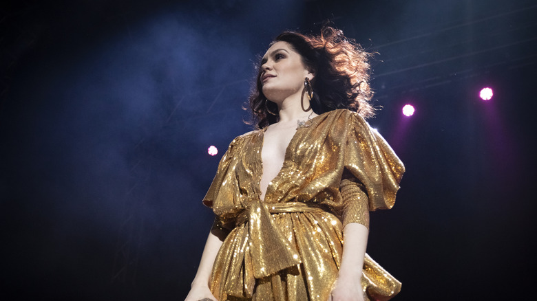 Jessie J performing in a golden tie-up dress