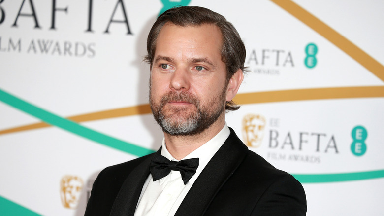 Joshua Jackson posing for photos in a tuxedo