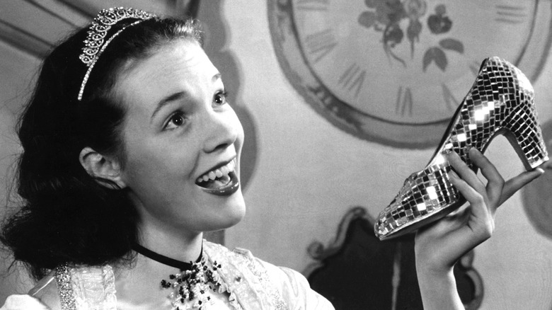 Young Julie Andrews wearing a tiara and holding a heeled shoe