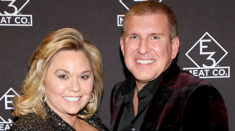 Julie and Todd Chrisley posing and smiling at an event