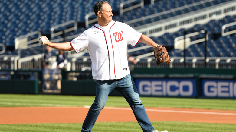 Doug Emhoff throwing a baseball while looking determined