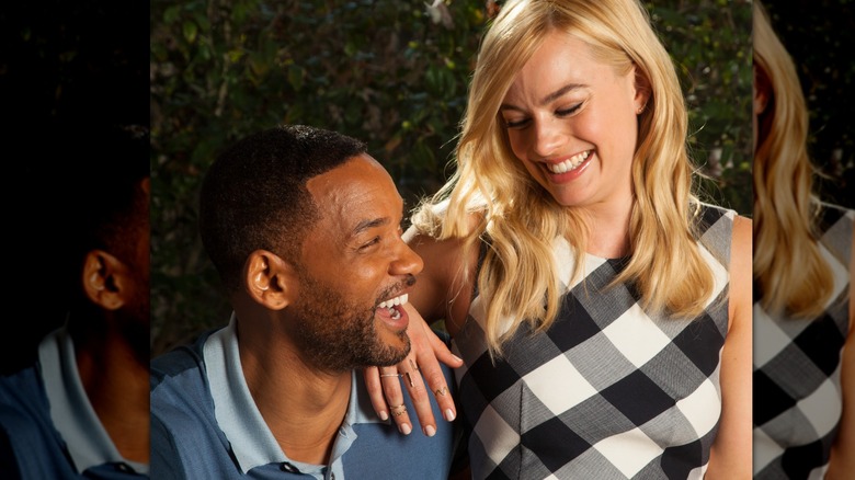 Will Smith and Margot Robbie posing together for promo pictures for their movie Focus