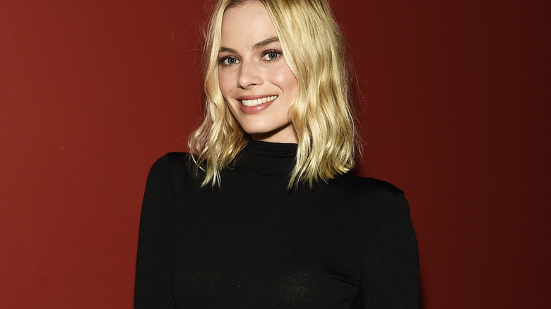 Margot Robbie standing in front of A red wall for AN I Tonya Q&A