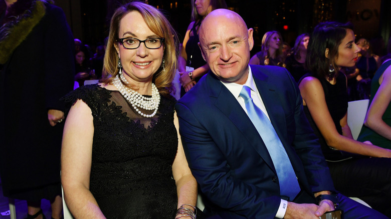 Gabby Giffords and Mark Kelly smiling while sitting at an event